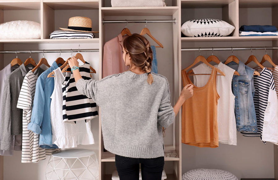 یک زن در حال انتخاب لباس از کمد لباس